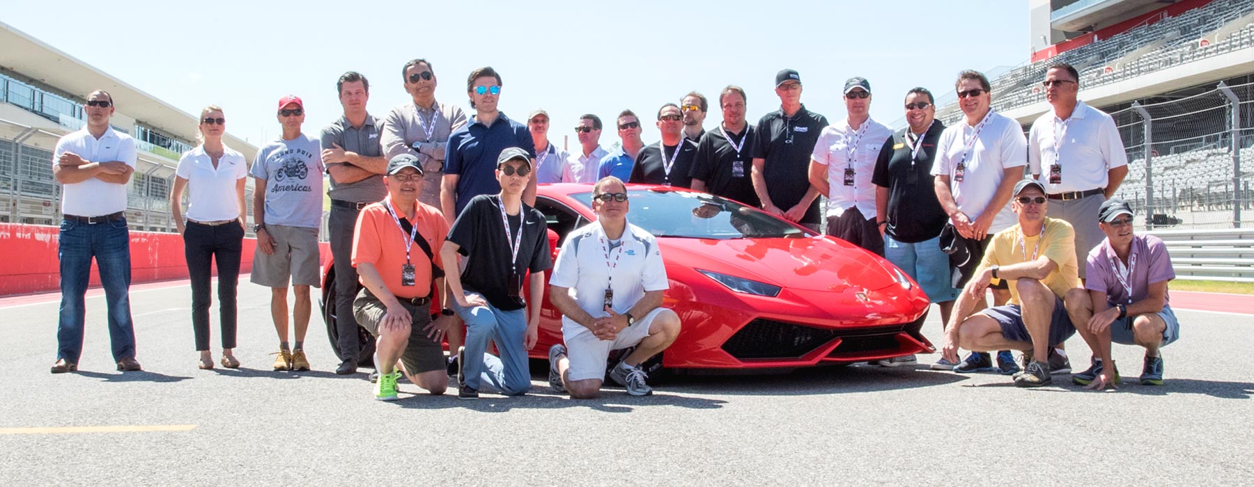 A corporate group event enjying a photo opportunity in front of a Lamborghini at Xtreme Xperience