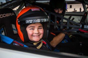 photo of a kid smiling during ride in a race car xtreme xperience