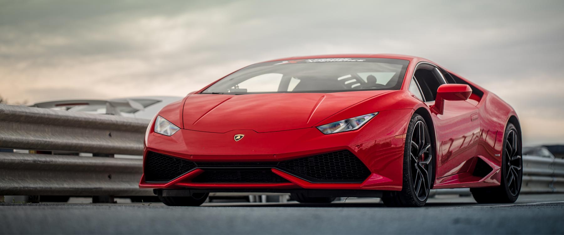 Photo of Xtreme Xperience Lamborghini Huracan in rosso mars, red at racetrack