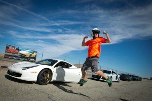 An ecstatic customer jumps for joy after his supercar driving experience at Willow Springs International Raceway