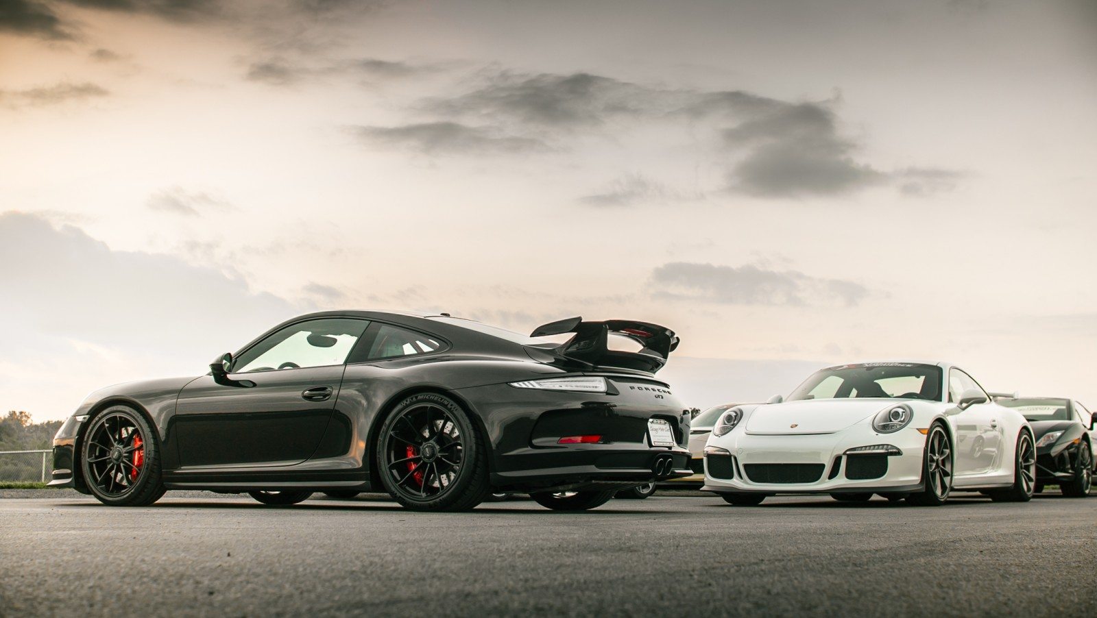 image xtreme xperience Porsche 911 GT3s in black and white at the track