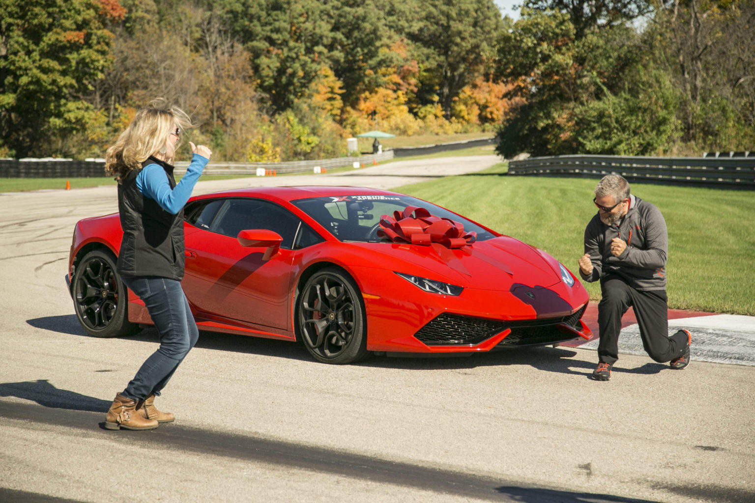 excited couple with surprise with lamborghini drive at race track