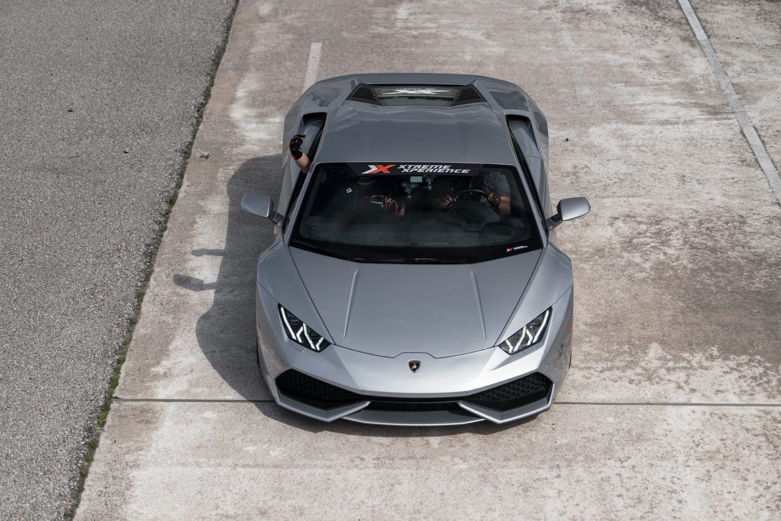Xtreme Xperience's Lamborghini Huracan parked on a racetrack.