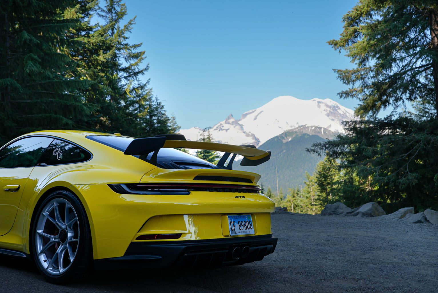 Xtreme Xperiences Open Road Porsche GT3 parked in front of mount rainier in Washington.
