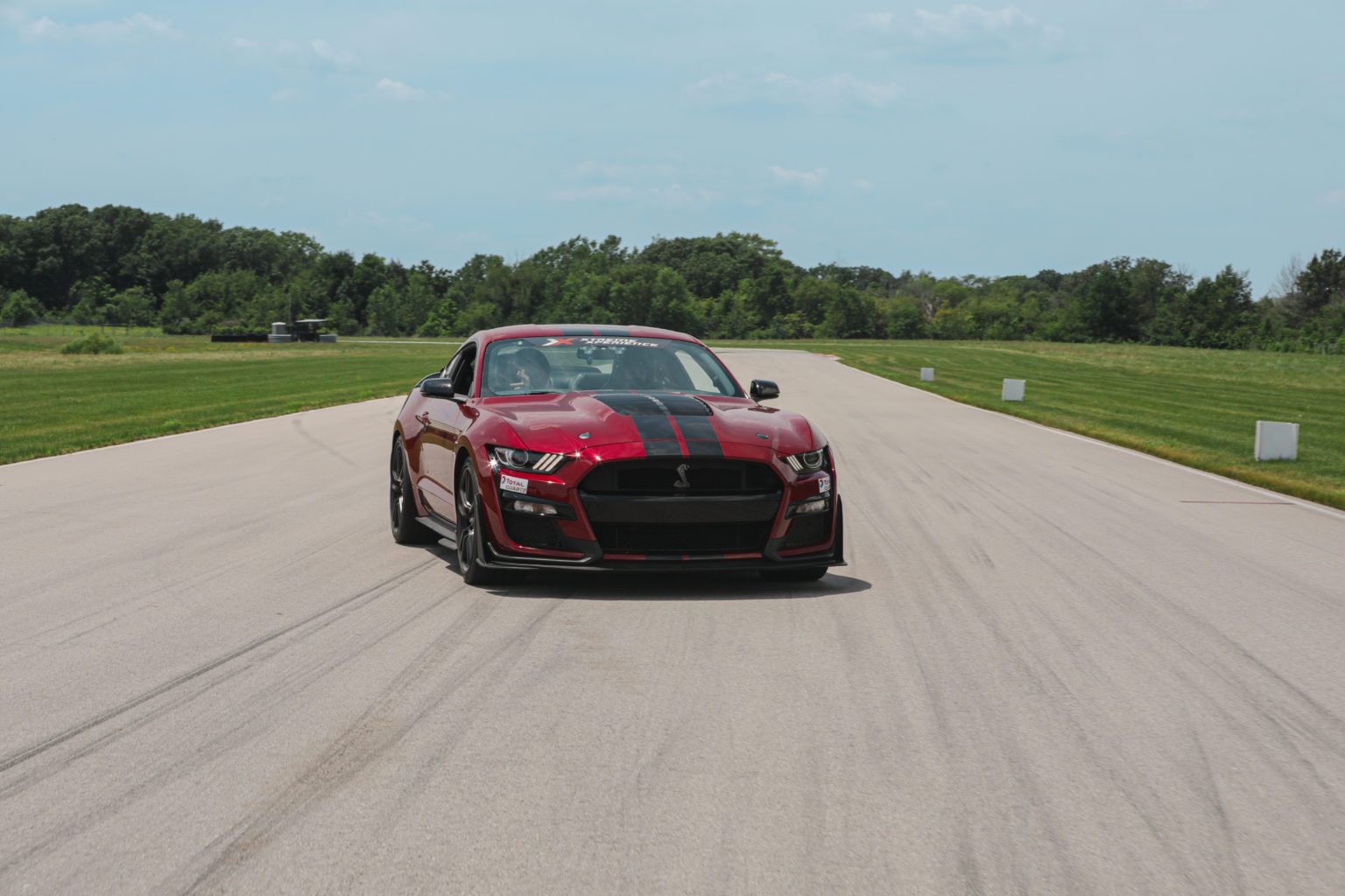 Xtreme Xperience.s Mustang Shelby GT500 driving on a racetrack